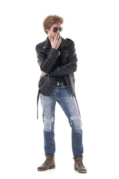 体贴自信的摇滚风格的年轻人吸着烟，俯视着冷漠。图片下载