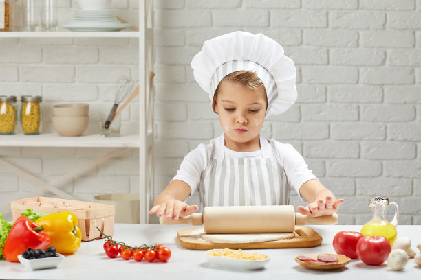小男孩戴着帽子，围着围裙做饭图片下载