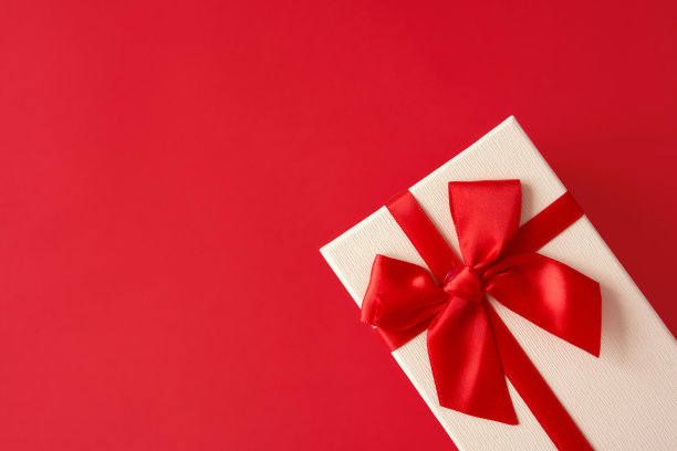 白色礼物与红色丝带在明亮的红色背景图片下载
