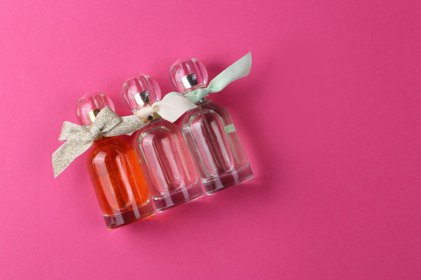 粉色背景上的女士香水瓶，深粉色背景上的顶部视图模型图片下载