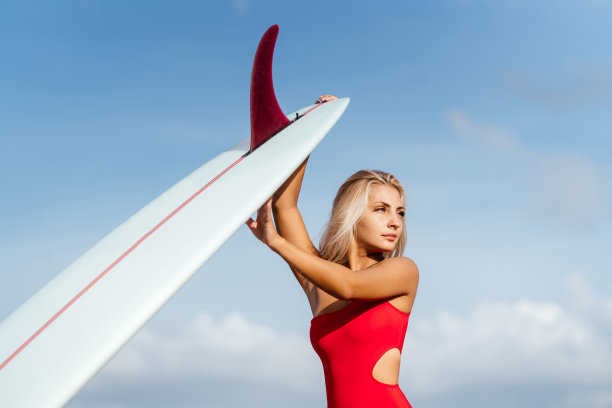 金发碧眼的冲浪女人去海洋。图片下载