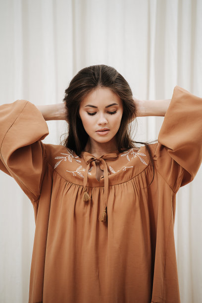 性感美丽的女人穿着浅棕色的衣服。正面的观点图片下载