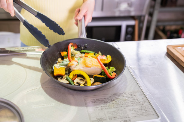 亚洲女人在厨房做饭，手，炒图片下载