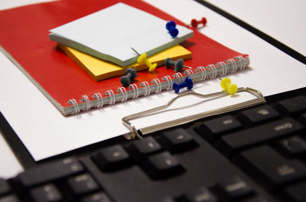 回形针，红色记事本，白色背景上的键盘图片下载