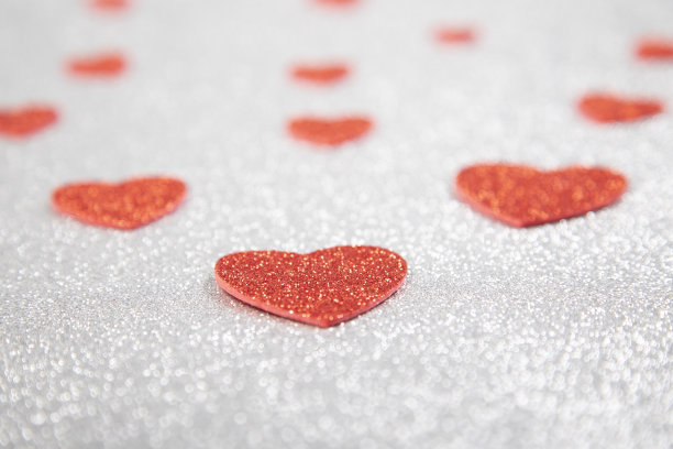 闪闪发光的红心在银色的闪闪发光的背景上图片下载