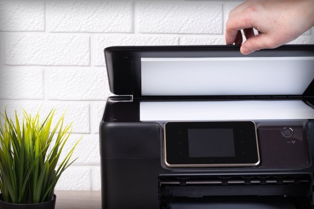 年轻人用一张白纸盖上了扫描仪的盖子。图片下载