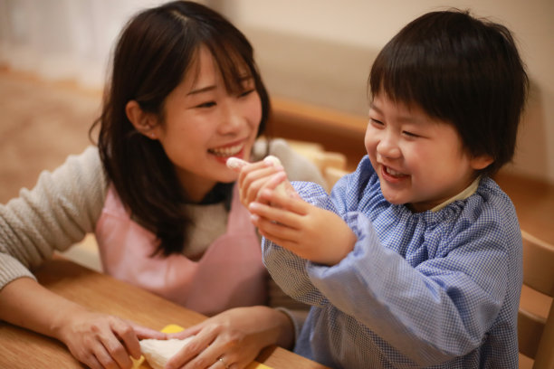 男孩和幼儿园老师玩粘土的形象图片下载