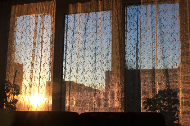 夕阳透过薄纱照在窗户上。晚上轮廓光。图片下载