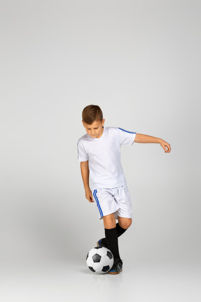 穿着衣服的小男孩在玩足球图片下载