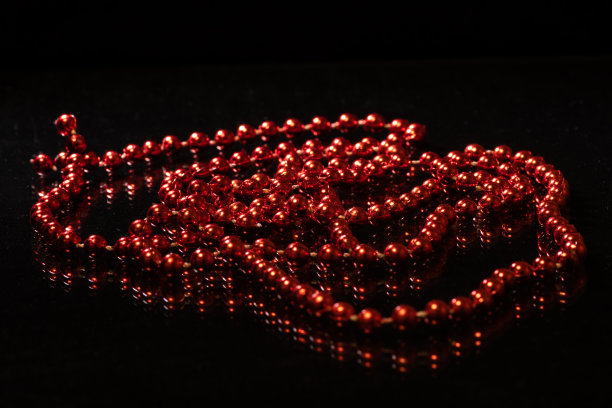 红色闪亮的珠子和反射在黑色的背景，拷贝空间，俯视图图片下载