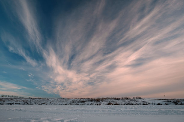 冬天，田野，雪，黄昏。美丽的日落天空，蓝色和粉红色的色调。图片下载