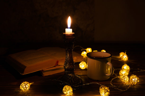 书和热茶杯，舒适的夜晚。假期心情照片与圣诞彩灯。木心和蜡烛。Hygge概念。完美的秋季平铺。图片下载