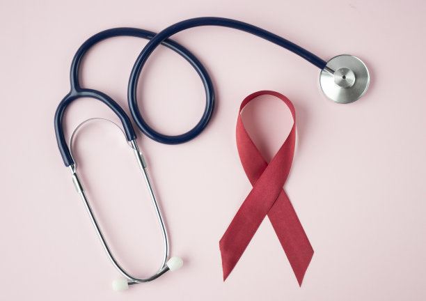混凝土背景上的红丝带和听诊器。12月1日世界艾滋病日，开展艾滋病防治运动。文本复制空间图片下载