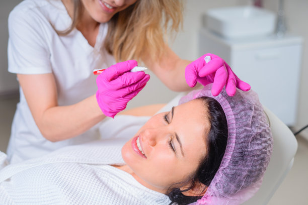 美容师在spa美容院进行美容前在病人脸上使用面部标记图片下载