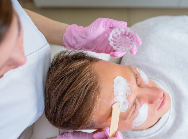 男性化妆品。在豪华水疗中心接受面部治疗的英俊男子图片下载