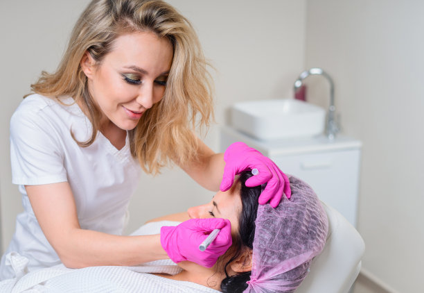 美容师在美容院美容前，在病人脸上使用面部标记物图片下载