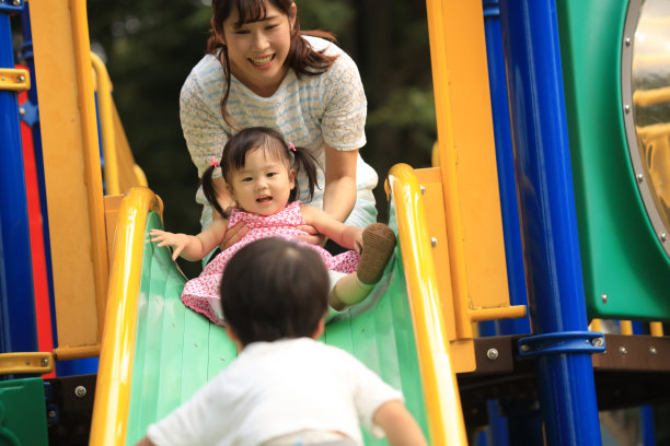 父母和孩子在滑梯上玩图片下载