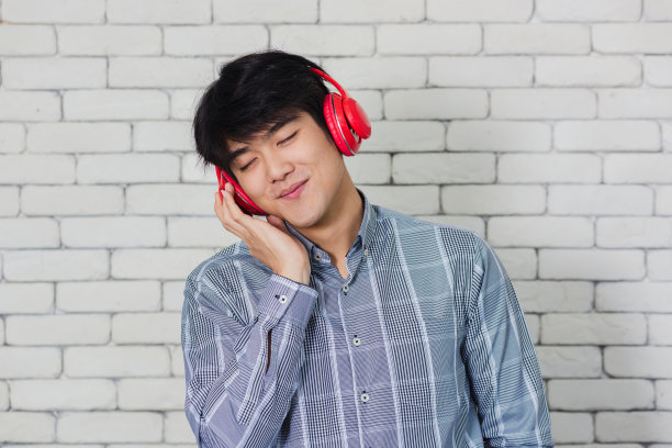 戴着红色耳机的男人站着图片下载