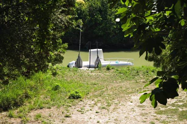 一艘白色的船停在河岸上(意大利，Pesaro，欧洲)图片下载