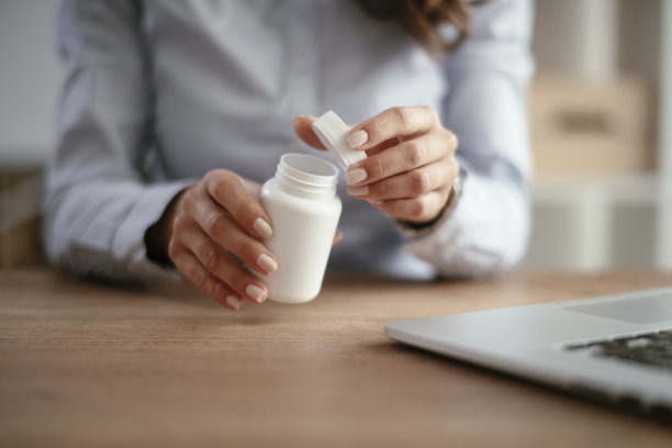 年轻的女商人喝着药。图片下载