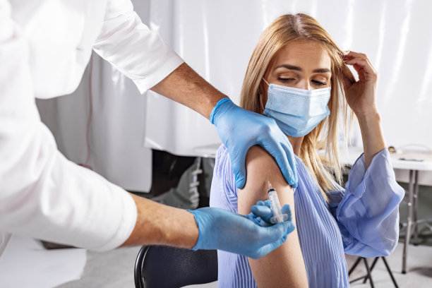 医生在一位女士的手臂上注射疫苗素材图片