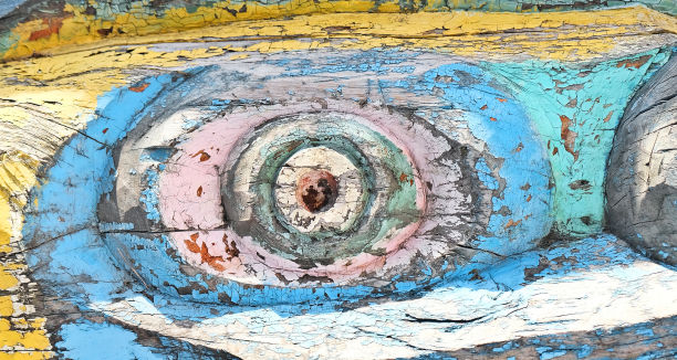 用木头雕刻的有裂纹的古老抽象人物。近距离观察油漆剥落的木质表面图片下载