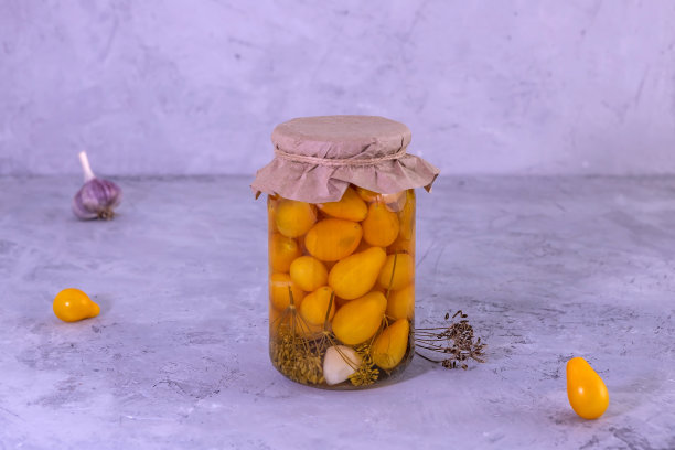 混凝土背景上的腌黄色小番茄。概念发酵食品，自制食品，冬季准备。图片下载