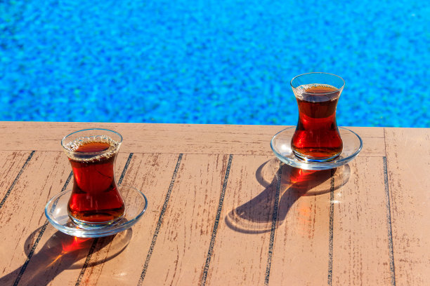 游泳池旁的桌子上放着热土耳其茶图片下载