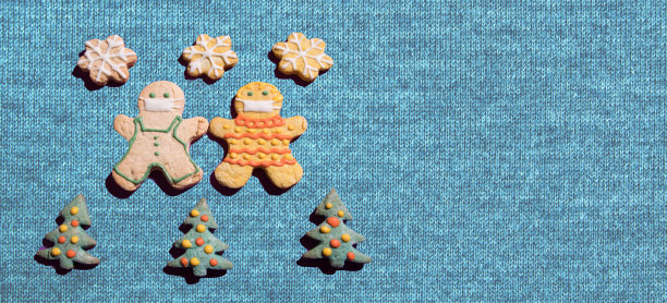 冠状病毒大流行期间超本地旅行的概念。姜饼人围绕着圣诞树编织的背景图片下载