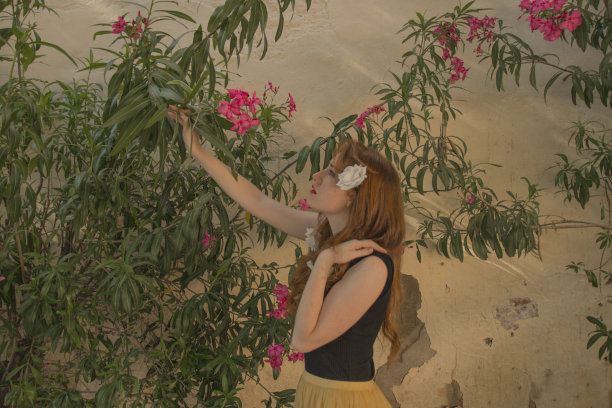 年轻温柔的红头发年轻女孩的肖像与健康的雀斑皮肤穿着黑色的顶摆出严肃或沉思的表情。白种人女性模特与姜头发摆姿势户外。图片下载