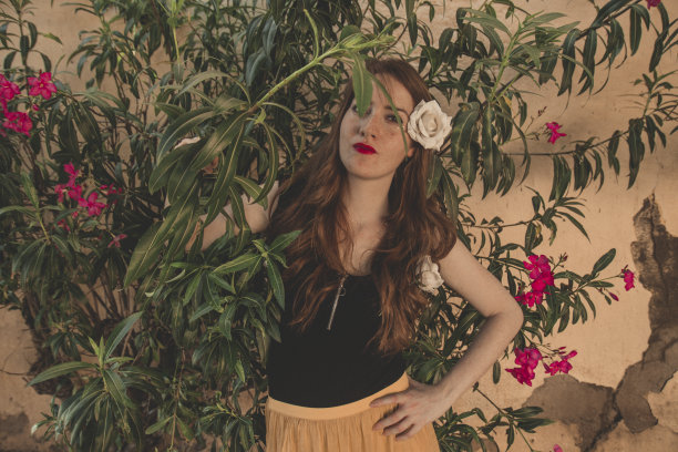 年轻温柔的红头发年轻女孩的肖像与健康的雀斑皮肤穿着黑色的顶摆出严肃或沉思的表情。白种人女性模特与姜头发摆姿势户外。图片下载