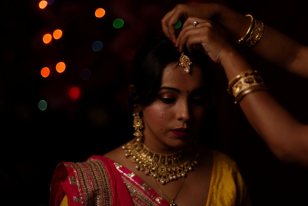 在排灯节的晚上，一个印度孟加拉美丽的黑发女人在五颜六色的光bokeh背景创造的小链灯的肖像。图片下载