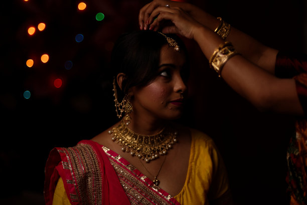 在排灯节的晚上，一个印度孟加拉美丽的黑发女人在五颜六色的光bokeh背景创造的小链灯的肖像。图片下载