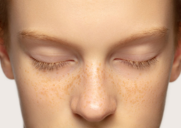 近距离拍摄美丽的红发白人女孩孤立在工作室背景。美容、时尚、护肤、化妆品概念。细节。图片下载