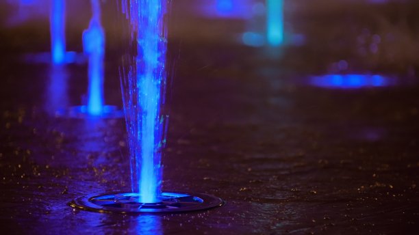 喷溅着五彩缤纷的喷泉。水被照亮，以不同的颜色落在一个喷泉，改变其水的颜色在夜晚。图片下载