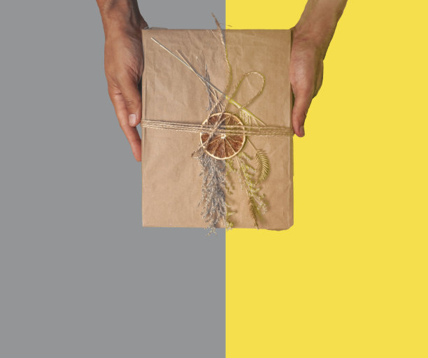 手工制作的礼品盒，用牛皮纸包装，用干花装饰。海报和横幅模板平铺照片与复制空间。年度色彩概念。图片下载