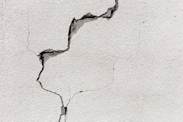阿拉伯联合酋长国Al Madam鬼村废弃房屋灰色混凝土墙上的裂缝，工业背景图片下载
