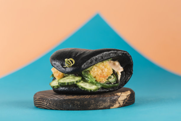 亚洲街头快餐包汉堡，面包虾，新鲜黄瓜和海藻在黑色墨鱼包素材图片