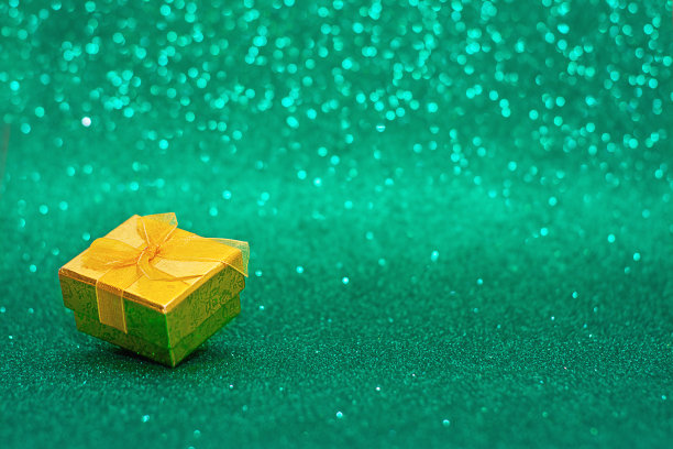 在绿色模糊的圣诞背景上的礼物盒，新年前夕图片下载