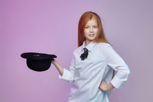 一个长红头发的少女手里拿着一顶帽子图片下载