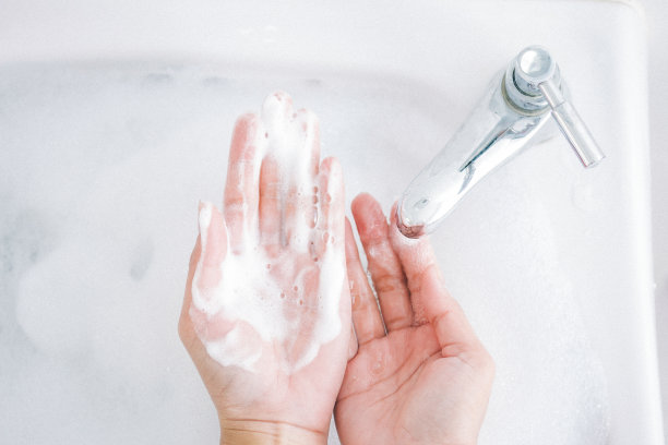 卫生的概念。用水在水龙头下用肥皂洗手图片下载