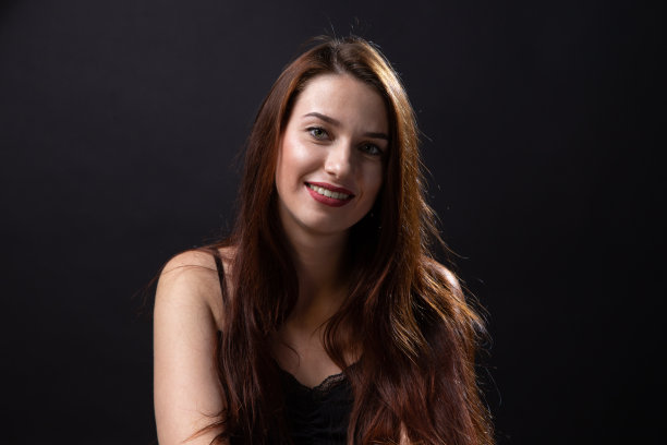 照片的年轻姜黄色女人与长头发在黑暗的背景图片下载