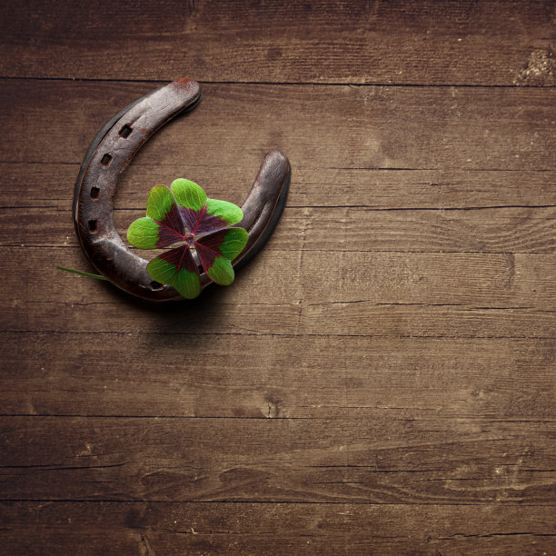 马蹄铁与幸运三叶草在木制背景图片下载