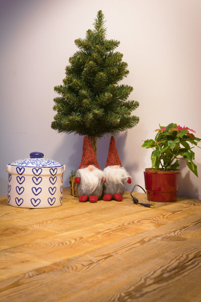 圣诞树下一张松木做的旧桌子上的节日小精灵图片下载