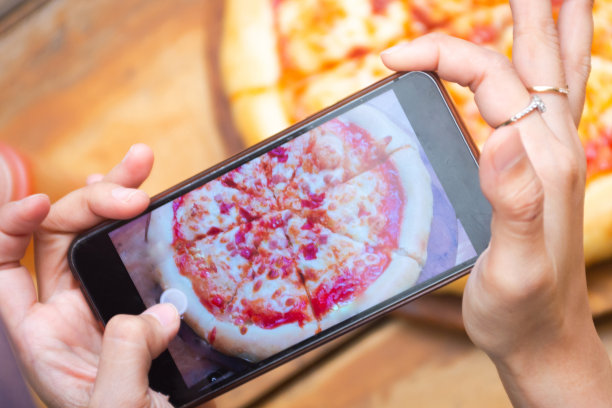 手拿着手机拍披萨图片下载