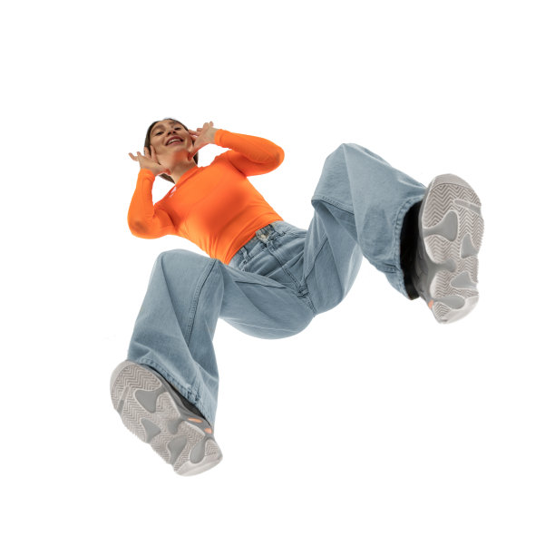 年轻时尚的女人在现代街头风格的服装孤立的白色背景，从底部拍摄图片下载