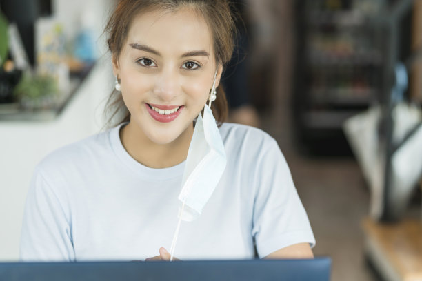 积极的亚洲商界女性摘下口罩，以开朗的笑容展示自己抗击新冠肺炎疫情的健康理念图片下载