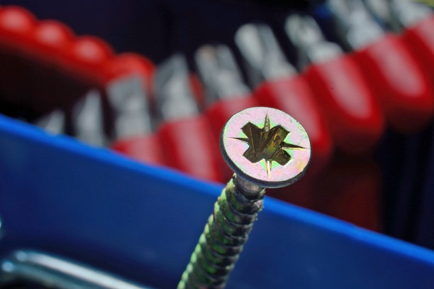 用螺丝刀在塑料工具箱里的黄色螺丝。特写镜头。图片下载