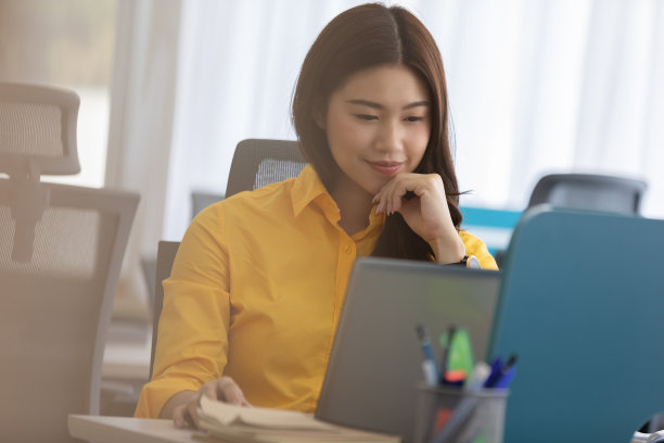 幸福迷人的亚洲女人在现代办公室或联合办公空间的商业创业的想法和要求，黄色衬衫与电脑笔记本电脑工作，创业概念图片下载
