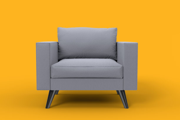 带枕头的灰色扶手椅，背景是工作室的黄色。图片下载
